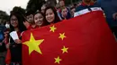 Para suporter wanita China membentangkan bendera negaranya di luar Stadion Maracana jelang upacara pembukaan Olimpiade 2016 di Rio de Janeiro, Brasil, (6/8). (REUTERS/Alkis Konstantinidis)