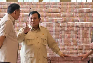 Presiden Prabowo Subianto (tengah) berbicara dengan Jaksa Agung Sanitiar Burhanuddin (kanan) dan Menteri Pertahanan Indonesia Sjafrie Sjamsoeddin di samping tumpukan uang kertas rupiah Indonesia senilai 800 juta USD di gedung Kejaksaan Agung Republik Indonesia, Jakarta, Senin 20 Oktober 2025. (BAY ISMOYO/AFP)