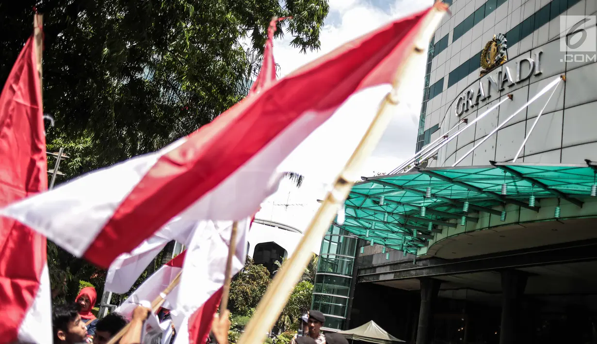 Massa dari Komite Penyelamat Asset Negara mengibarkan bendera Merah Putih saat berunjuk rasa di Gedung Granadi, Jakarta, Senin (17/12). Mereka menuntut penyitaan sejumlah aset milik Yayasan Supersemar, termasuk Gedung Granadi. (Liputan6.com/Faizal Fanani)