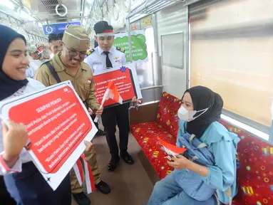 Petugas KRL Commuterline membawa poster saat peringatan Hari Sumpah Pemuda di Stasiun Bogor, Jawa Barat, Senin (28/10/2024). (merdeka.com/Arie Basuki)