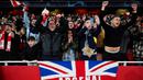 Pendukung Arsenal merayakan kemenangan timnya atas Porto pada laga leg kedua 16 besar Liga Champions 2023/2024 di Emirates Stadium, London, Inggris, Rabu (13/03/2024). (AFP/Adrian Dennis)