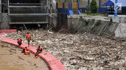Petugas Dinas Lingkungan Hidup Pemprov DKI saat membersihkan sampah yang memenuhi sekitar Pintu Air Manggarai, Jakarta, Minggu (8/4). Menurut petugas, sebanyak 312 meter kubik sampah memenuhi pintu air. (Merdeka.com/Iqbal Nugroho)