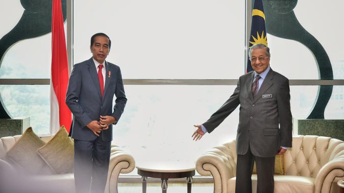 Presiden Joko Widodo dan Perdana Menteri Malaysia Mahathir Mohamad saat melakukan pertemuan di Putrajaya (8/8/2019). Pertemuan ini merupakan kunjungan balasan yang dilakukan PM Mahathir tahun lalu. (Farhan Abdullah/Department Of Information/AFP)