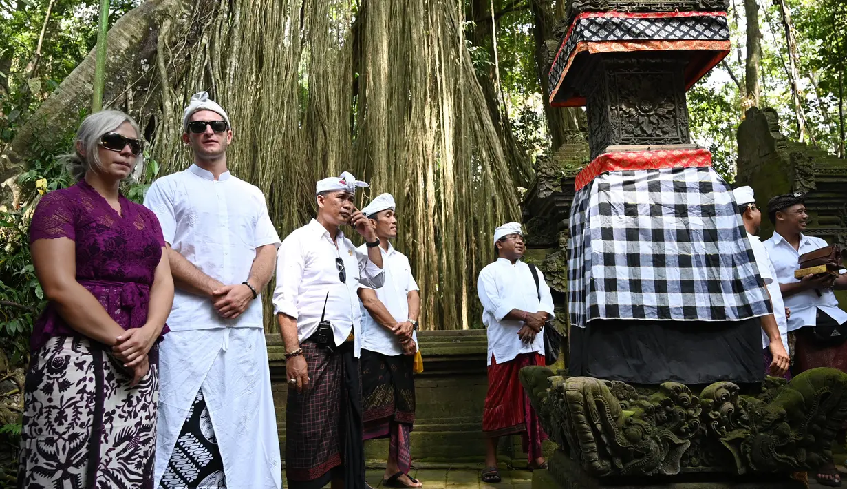 Turis Ceko, Sabina Dolezalova (kiri) dan Zdenek Slouka (dua kiri) saat akan mengikuti upacara guru piduka di Pura Beji, Ubud, Bali, Kamis (15/8/2019). Sabina dan Zdenek sudah meminta maaf atas ulah mereka yang cebok menggunakan air suci di pancuran Pura Beji. (SONNY TUMBELAKA/AFP)