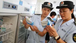 Petugas BPOM China memeriksa vaksin rabies di Pusat Pengendalian dan Pencegahan Penyakit di Huaibei, provinsi Anhui, Selasa (24/7). Otoritas China menginvestigasi skandal produksi vaksin rabies ilegal yang telah menimbulkan kepanikan masyarakat. (AFP)