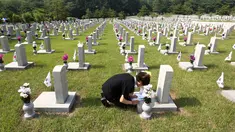 Warga Korea Selatan, Oh Myung-Soon menangis di depan batu nisan saudaranya yang meninggal selama Perang Korea di pemakaman nasional, Seoul, Korea Selatan, Rabu (6/6). Kegiatan ini dilakukan dalam Memorial Day. (AP Photo/Ahn Young-joon)