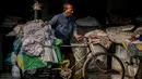 Seorang pekerja mengumpulkan pakaian yang sudah dicuci untuk dikeringkan di binatu terbuka, yang secara lokal disebut 'Dhobi Ghat' di New Delhi, India pada 14 Maret 2022. Dhobi Ghat adalah tempat yang menyediakan layanan cuci dengan cara tradisional. (Money SHARMA / AFP)