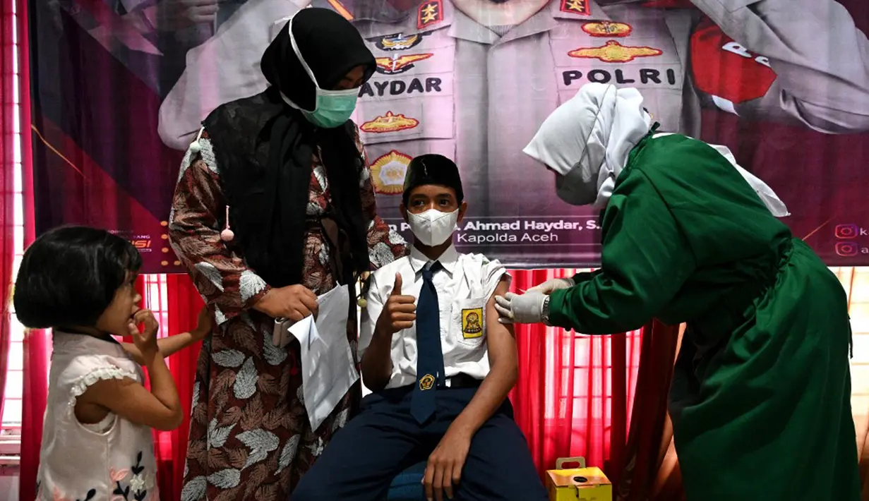 Seorang siswa sekolah menengah pertama menerima dosis vaksin Sinovac pada acara vaksinasi virus corona COVID-19 di Blang Bintang, Provinsi Aceh, 21 September 2021. (CHAIDEER MAHYUDDIN/AFP)