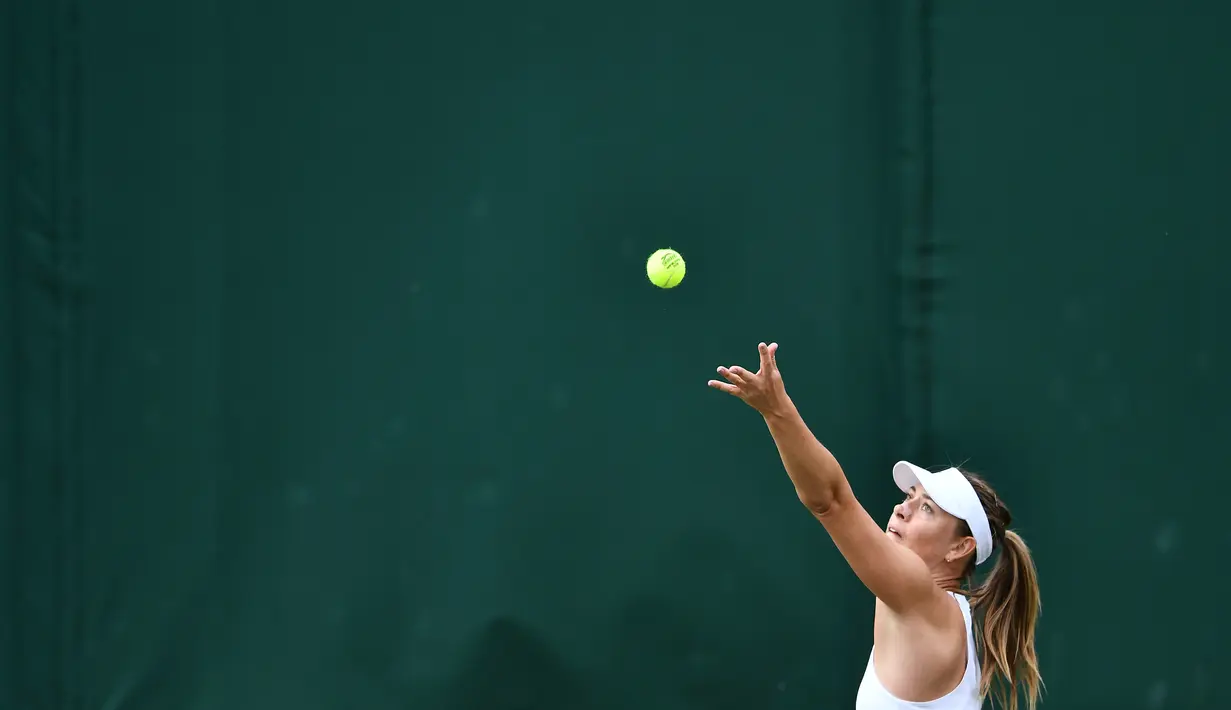 Petenis Rusia Maria Sharapova menservis bola saat bertanding melawan petenis Prancis, Pauline Parmentier dalam pertandingan tunggal putri di hari kedua Wimbledon Tennis Championships di London, Inggris (2/7/2019). Sharapova takluk atas Parmentier 6-4, (4) 6-7, 0-5. (AFP Photo/Ben Stansall)
