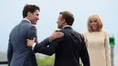 Presiden Prancis Emmanuel Macron (tengah) disaksikan istrinya Brigitte Macron (kanan) menyambut kedatangan Perdana Menteri Kanada Justin Trudeau (kiri) di KTT G7, Biarritz, Prancis, Sabtu (24/8/2019). (Sean Kilpatrick/The Canadian Press via AP)