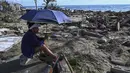 Warga beristirahat di tengah puing-puing rumah yang rusak akibat Badai Melissa di desa Boca de Dos Rios, provinsi Santiago de Cuba, Kuba, pada Kamis 30 Oktober 2025. Pihak berwenang mengatakan sekitar ratusan ribu warga masih berada di tempat penampungan. (YAMIL LAGE/AFP)