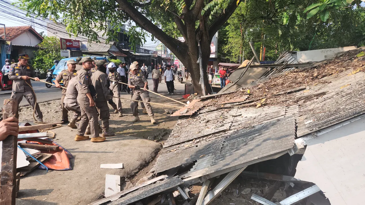 Satpol PP Kota Depok saat menertibkan bangunan liar milik pedagang di Jalan Raya Cipayung, Depok.