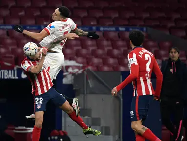 Bek Atletico Madrid, Mario Hermoso (kiri) bersaing dengan gelandang Sevilla, Lucas Encamps dalam lanjutan Liga Spanyol 2020/2021  di Stadion Wanda Metropolitano, Madrid, Spanyol, Rabu (13/1/2021) dini hari WIB. Atletico Madrid membungkam Sevilla dengan skor 2-0. (PIERRE-PHILIPPE MARCOU / AFP)