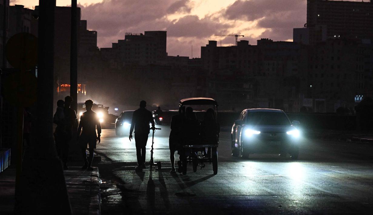 Orang-orang beraktivitas di jalanan tanpa aliran listrik selama pemadaman listrik nasional di Havana, Kuba pada Sabtu 21 Maret 2026. Hampir seluruh wilayah pulau Kuba kembali dilanda pemadaman listrik total (blackout nasional) pada 21 Maret 2026. (Yamil LAGE/AFP)