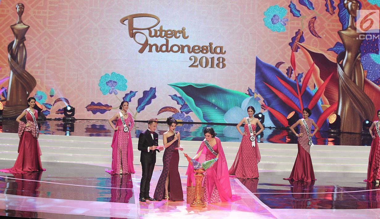 Finalis dari Sumatera Selatan, Berlinda Permatasari mengambil payung untuk menjawab pertanyaan dari Juri, Bambang Soesatyo pada malam puncak Puteri Indonesia 2018 di JCC, Jakarta, Jumat (9/3). (Liputan6.com/Herman Zakharia)