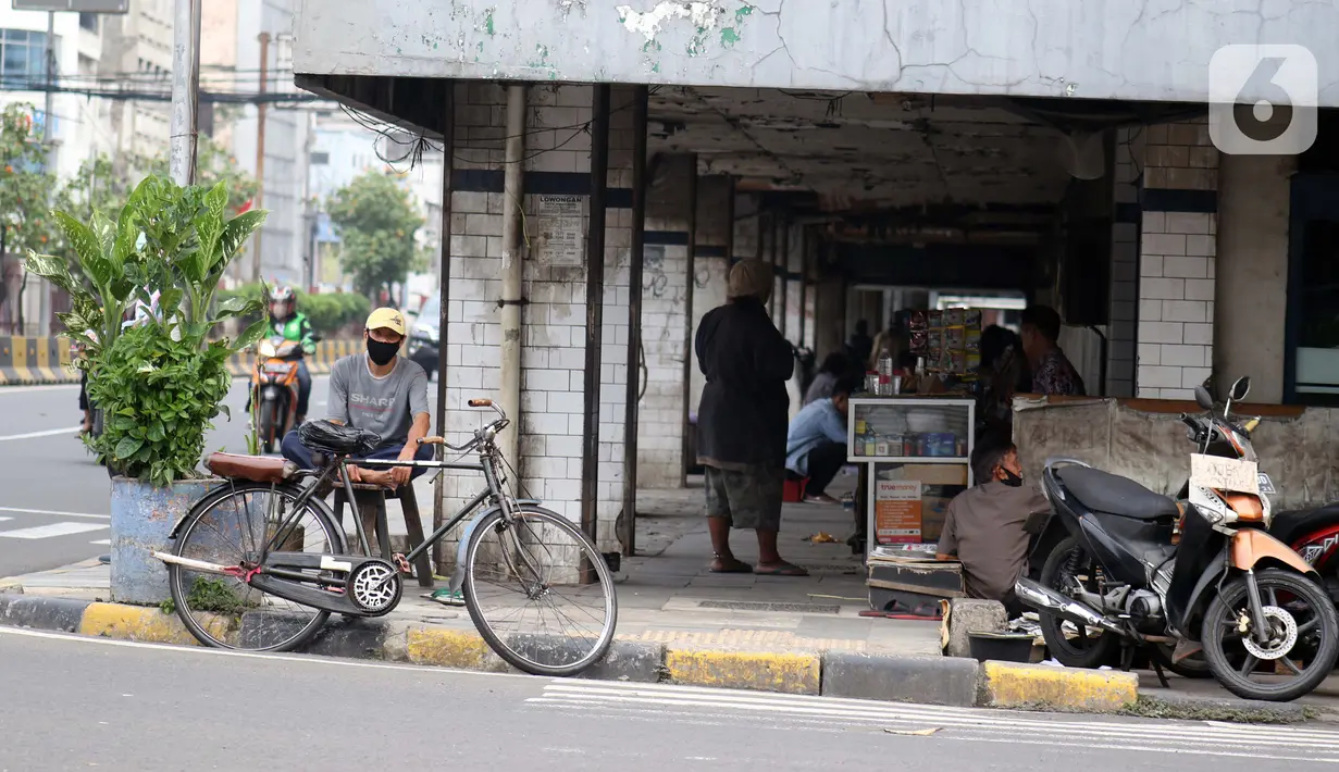Pengojek sepeda menunggu penumpang di kawasan Pasar Asemka, Jakarta, Selasa (21/4/2020). Penghentian sementara aktivitas sebagian besar pertokoan dan perkantoran seiring pelaksanaan WFH dan PSBB berimbas pada sulitnya pengojek sepeda mencari penumpang. (Liputan6.com/Helmi Fithriansyah)