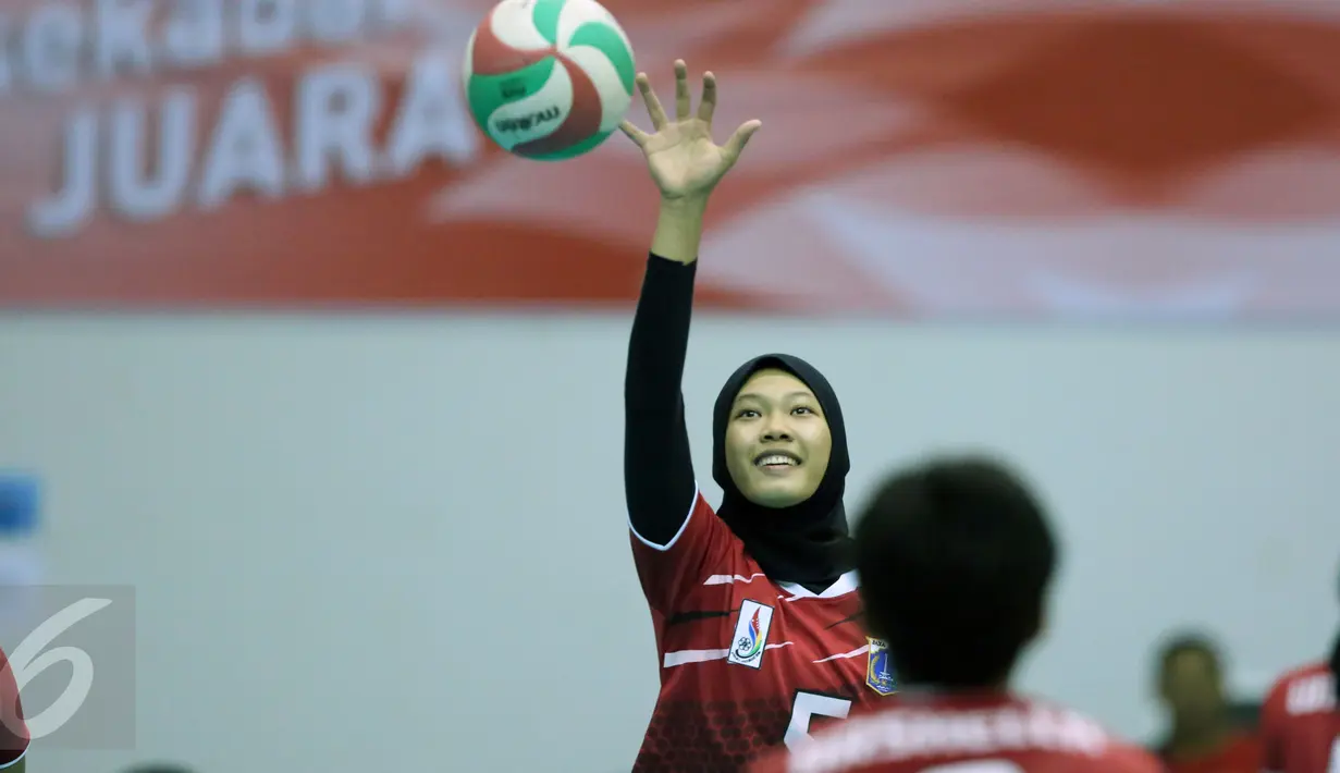 Pevoli putri DKI Jakarta, Reska Nurdiani S (kiri) berlatih smes saat laga melawan Papua di fase grup Y PON XIX Jabar di Gelora Sabilulungan, Kab Bandung, Rabu (21/9). DKI Jakarta unggul tiga set (25-21, 25-21, 25-19). (Liputan6.com/Helmi Fithriansyah)