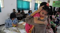 Seorang anak anggota TNI digendong ibunya usai mengikuti vaksinasi ulang di Kantor Kesehatan Kopassus Jakarta, Senin (18/7). Kopassus menggelar vaksinasi ulang terhadap anak prajurit yang terindikasi menjadi korban vaksin palsu (Liputan6.com/Helmi Afandi)