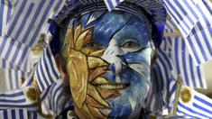 Salah satu pendukung timnas Uruguay mewarnai wajahnya dengan bendera negaranya saat mendukung timnya melawan Argentina pada laga kualifikasi Piala Dunia 2018 di Montevideo, Uruguay, (31/8/2017). Argentina imbang 0-0 lawan uruguay. (AP/Matilde Campodonico)