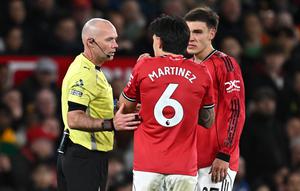 Wasit asal Inggris, Paul Tierney, berbicara dengan bek Manchester United, Lisandro Martínez, setelah ia menarik rambut striker Inggris milik Leeds United, Dominic Calvert-Lewin, yang berujung pada kartu merah untuk Martínez dalam pertandingan Premier League antara Manchester United dan Leeds United di Old Trafford, Manchester, Inggris barat laut, pada 13 April 2026. (Paul ELLIS / AFP)