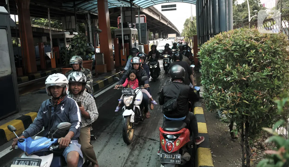 Pengendara motor melintasi Gerbang Tol Pulomas saat dialihkan akibat banjir di kawasan Cempaka Putih, Jakarta, Minggu (23/2/2020). Banjir yang melanda kawasan tersebut melumpuhkan akses di Jalan Ahmad Yani sehingga Gerbang Tol Pulomas dibuka untuk pengendara motor. (merdeka.com/Iqbal S. Nugroho)