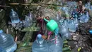 Warga  mengambil air untuk minum dan kebutuhan mck rumah  di sumber mata air Sumur Bendung, Gunung Batur, Kota Cilegon, Banten, Minggu, (15/7/2026). (KLY/Arie Basuki)