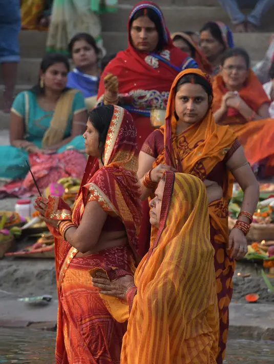 Umat Hindu India mengambil bagian dalam ritual pemujaan dewa matahari selama Festival Chhath Puja di tepi sungai Gangga, Varanasi, Selasa (13/11). Festival Hindu kuno ini dilakukan sebagai bentuk terima kasih kepada Dewa Matahari (Dominique FAGET / AFP)