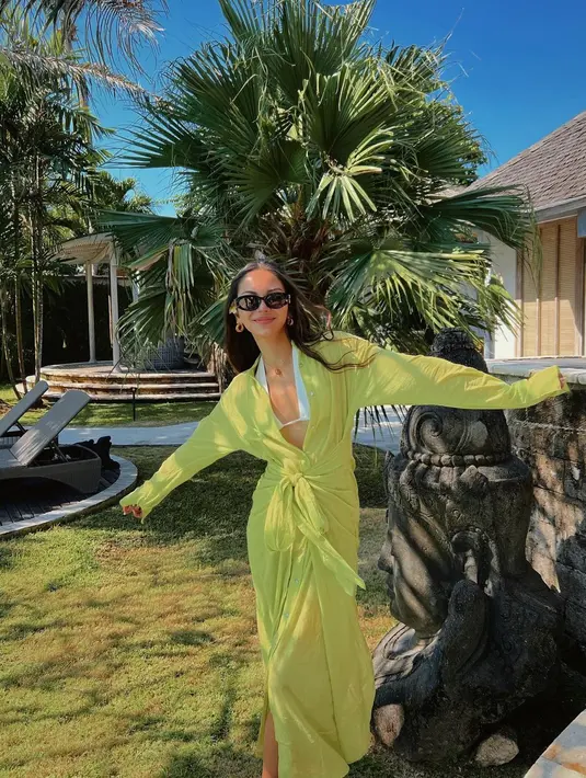 Di siang hari, Alyssa juga tidak ingin ketinggalan tropical vibes di Bali. Ia pun mengenakna bikini putih yang dipadukan dengan twisted shirt dress berwarna hijau neon (instagram/alyssadaguise)