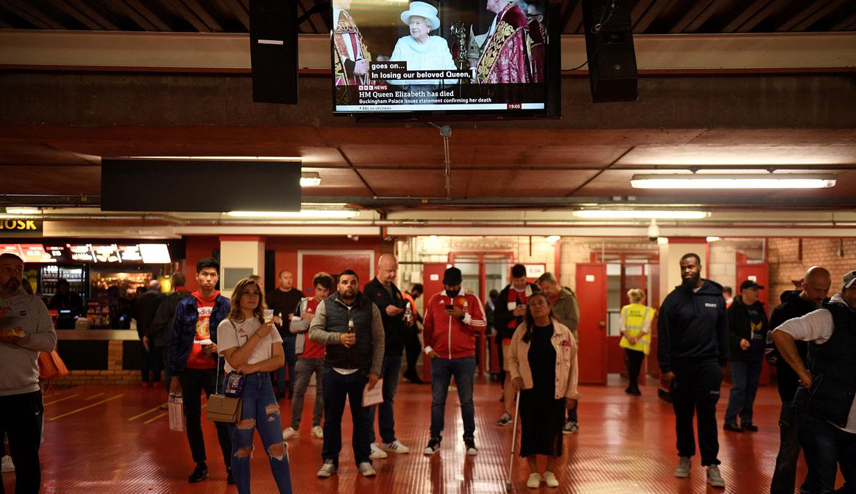 Penonton di Old Trafford tengah menyaksikan berita meninggalnya Ratu Elizabeth II saat menunggu laga Grup E Liga Europa antara Manchester United melawan Real Sociedad, Kamis (8/9/2022) waktu setempat. (AFP/Oli Scarff)