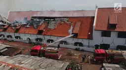 Petugas pemadam kebakaran memadamkan sisa api yang membakar Museum Bahari, Jakarta Utara, Selasa (16/1). Api melahap Gedung A Blok 1 dan 2 dan Gedung C Blok 1 dan 2 tempat penyimpanan benda-benda bersejarah di bidang bahari. (Liputan6.com/Arya Manggala)