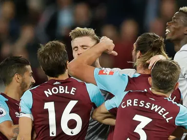 Pemain West Ham United dan pemain Manchester United terlibat saling dorong saat bertanding dalam Liga Inggris di London Stadium di London (10/5). Manchester United bermain imbang tanpa gol melawan West Ham United. (AP Photo / Alastair Grant)
