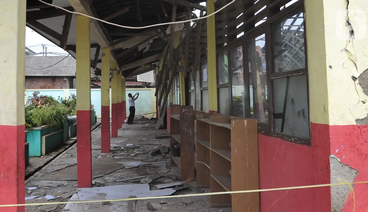 Seorang pria mengambil gambar bangunan sekolah yang ambruk di SDN Malangnengah II, di Kampung Jaha, Desa Malang Negah, Kec. Pangedagang, Kab. Tangerang, Rabu (13/11/2019). Tiga ruang kelas di SD itu roboh akibat kontur tanah di lingkungan sekolah yang ambles karena hujan. (merdeka.com/Arie Basuki)