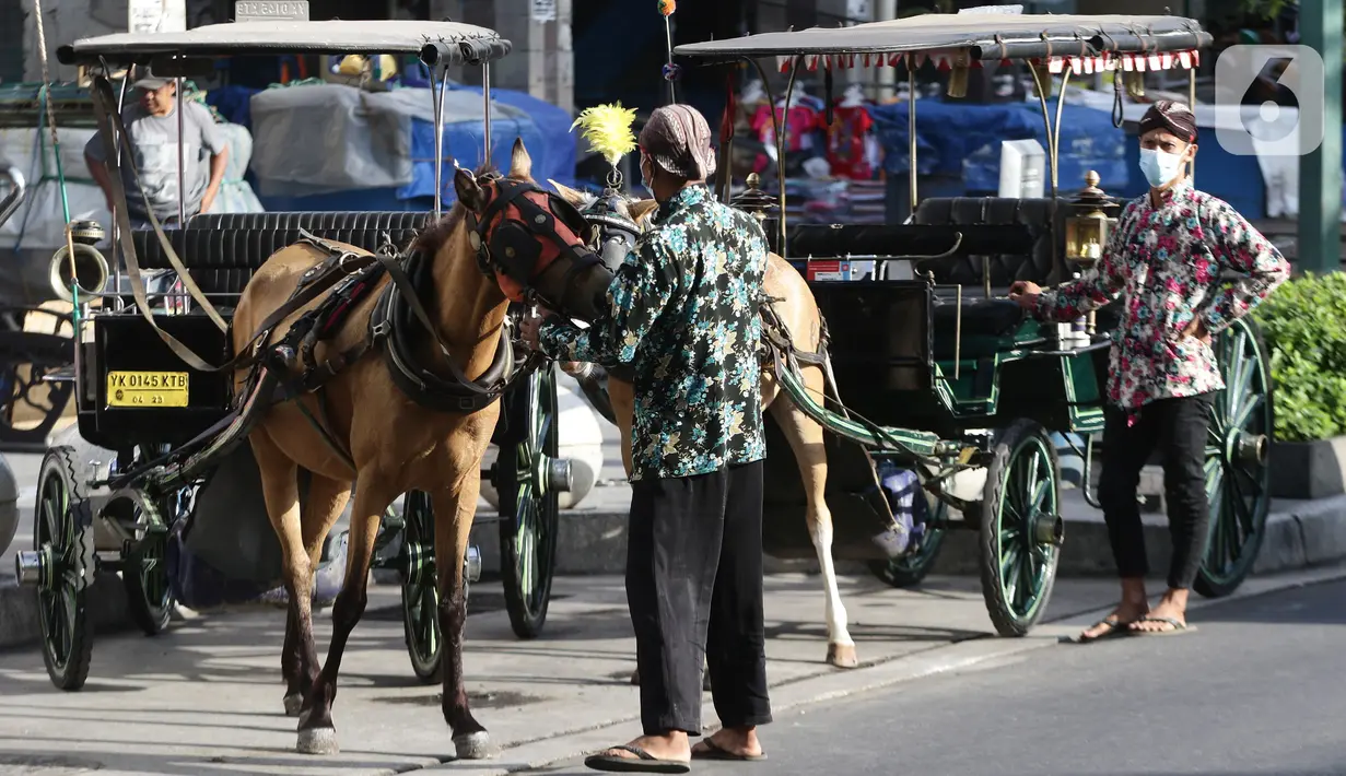 Pengemudi delman menunggu penumpang di kawasan Jalan Malioboro, Yogyakarta, Minggu (10/10/2021). Wisatawan yang berkunjung di kawasan wisata Yogyakarta wajib mematuhi dan menerapkan protokol kesehatan karena Daerah Istimewa Yogyakarta masih berstatus PPKM level 3. (Liputan6.com/Helmi Fithriansyah)