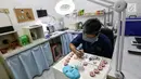 Rizwan Ilyasin sedang mengecat bola mata palsu di Klinik Ilyarsi Okularis, Ciputat, Tangerang Selatan, Banten, Sabtu (3/2). Putri Ilyasin harus kehilangan bola mata karena kanker. (Liputan6.com/Fery Pradolo)