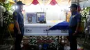 Dua petugas kepolisian berjaga di dekat peti jenazah rekannya, Rancel Cruz yang tewas oleh pecandu narkoba di Manila, Filipina, (19/10). Sebanyak 1.900 orang tewas akibat perang narkoba di Filipina. (REUTERS/Erik De Castro)