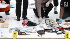 Petugas mengecek dan mengidentifikasi barang temuan yang diduga milik penumpang pesawat Lion Air JT 610 di Pelabuhan JICT 2, Jakarta, Selasa (30/10). Sejumlah barang ditemukan petugas gabungan dalam operasi pencarian. (Liputan6.com/Helmi Fithriansyah)