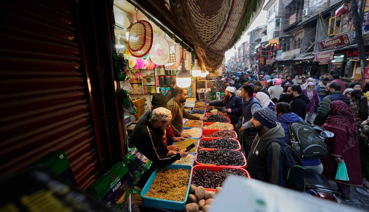 Di berbagai negara, kurma menjadi penganan yang kerap dicari pada bulan Ramadan sebagai kudapan manis untuk berbuka puasa. Tampak dalam foto, umat Muslim Kashmir berbelanja untuk kebutuhan bulan suci Ramadan di sebuah pasar di Srinagar, Rabu 18 Februari 2026. (AP Photo/Mukhtar Khan)