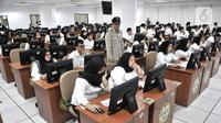Kepala Badan Kepegawaian Negara (BKN) Bima Haria Wibisana (tengah) meninjau pelaksanaan Seleksi Kompetensi Dasar (SKD) berbasis Computer Assisted Test (CAT) untuk Calon Pegawai Negeri Sipil (CPNS) di Kantor BKN Pusat, Jakarta, Senin (27/1/2020). (merdeka.com/Iqbal S. Nugroho)