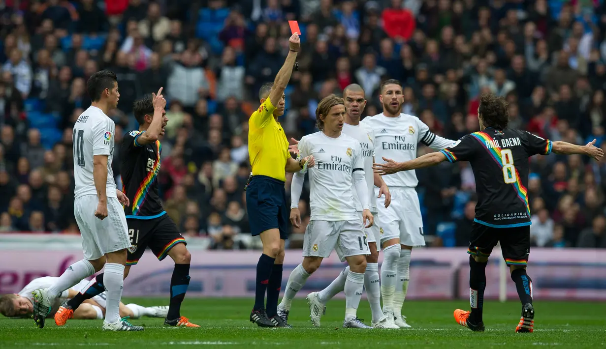 Wasit memberikan kartu merah kepada gelandang Rayo Vallecano Jose Raul Baena (kanan ) pada lanjutan liga Spanyol di Santiago Bernabeu (20/12). Real Madrid menang telak atas Rayo Vallecano dengan skor 10-2. (AFP/curto DE LA TORRE)