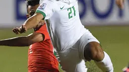 Andik Vermansyah dijegal Muhanna Shakir Hamzah saat Indonesia versus Singapura di Piala AFF 2016, Manila, Jumat (25/11). Andik menyumbang satu gol untuk kemenangan Indonesia dengan skor akhir 2-1. (AFP PHOTO / Ted Aljibe)