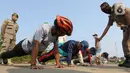 Pelanggar PSBB dihukum push up di kawasan Stadion Pakansari, Kabupaten Bogor, Minggu (6/9/2020). Pemkab Bogor menghukum pelanggar PSBB dengan denda Rp 100 ribu serta sanksi sosial seperti membersihkan area makam, push up, dan mempraktikkan prosesi pemakaman. (Liputan6.com/Herman Zakharia)