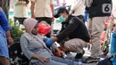 Petugas Dinas Kesehatan DKI Jakarta mengecek seorang warga yang mengalami pendarahan karena kelelahan saat CFD di Kawasan Bundaran HI, Jakarta, Minggu (14/8/2022). Warga tersebut langsung mendapatkan penanganan medis dan di bawa ke rumah sakit terdekat. (Liputan6.com/Angga Yuniar)