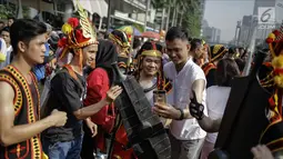 Warga berfoto bersama dengan mengenakan atribut budaya Kepulauan Nias saat CFD di Kawasan Jalan Sudirman, Jakarta, Minggu (4/3). Warga antusias dengan acara parade ini, karena mereka bisa menjajal pakaian adat Kepulauan Nias. (Liputan6.com/Faizal Fanani)