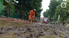 Petugas pemadam kebakaran membersihkan sisa lumpur pascabanjir yang merendam kawasan Bukit Duri, Jakarta, Sabtu (4/1/2020). Meski banjir sudah mulai surut, jalan-jalan dan permukiman warga masih tertutup lumpur tebal. (merdeka.com/Imam Buhori)