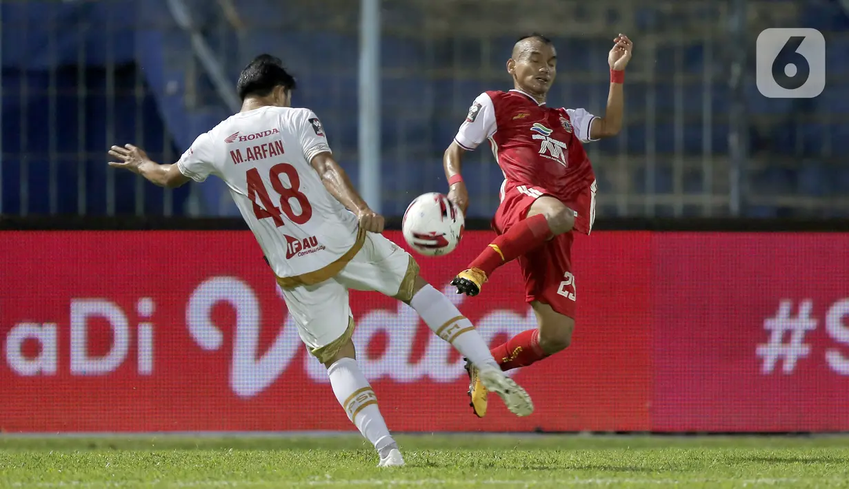 Pemain PSM Makassar M. Arfan (kiri) berebut bola dengan pemain Persija Jakarta Riko Simanjuntak dalam pertandingan babak penyisihan Piala Menpora 2021 di Stadion Kanjuruhan, Malang, Jawa Timur, Senin (22/3/2021). PSM Makassar menang dengan skor 2-0. (Bola.com/Arief Bagus)