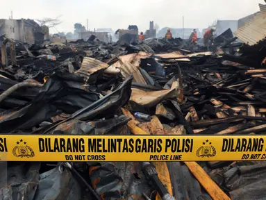 Garis polisi terpasang di lokasi kebakaran yang melanda wilayah permukiman di Jalan Gotong Royong, RW 002 Pondok Bambu, Jakarta, Senin (8/8). Polisi masih mengusut penyebab kebakaran yang menghanguskan 90 rumah tersebut. (Liputan6.com/Johan Tallo)