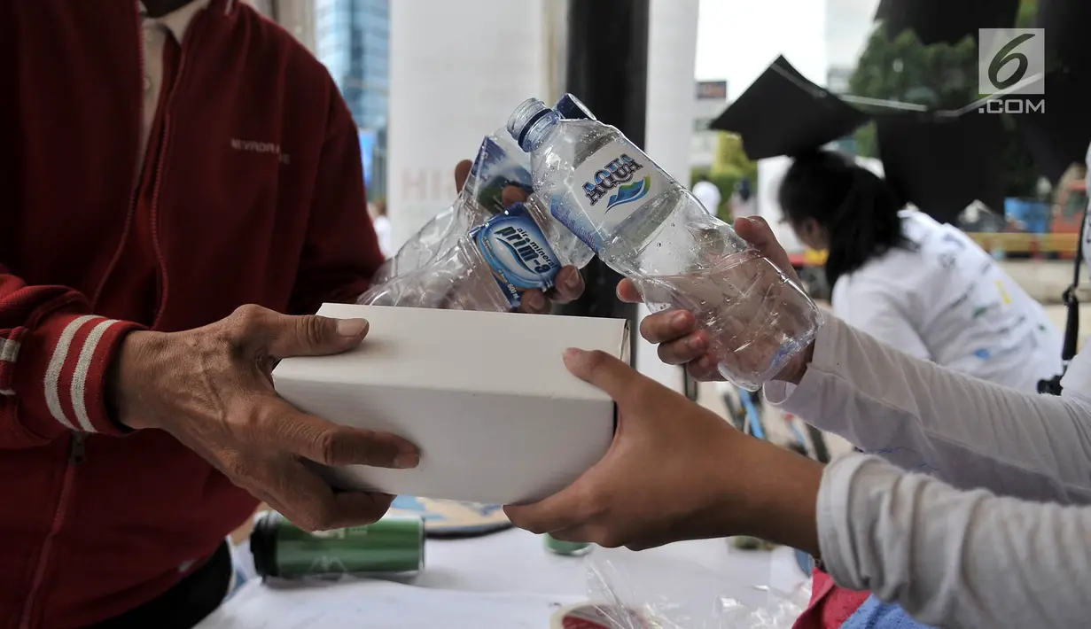 Warga menukarkan botol bekas dengan hadiah di stan ENVIRUN selama hari bebas kendaraan atau car free day (CFD) di Jakarta, Minggu (8/4). (Merdeka.com/Iqbal Nugroho)