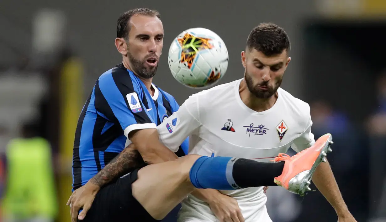 Bek Inter Milan, Diego Godin berebut bola dengan penyerang Inter Milan, Patrick Cutrone pada pertandingan lanjutan Liga Serie A Italia di di stadion San Siro di Milan, Italia, Rabu, (22/7/2020). Inter Milan bermain imbang 0-0 atas Fiorentina. (AP Photo/Luca Bruno)