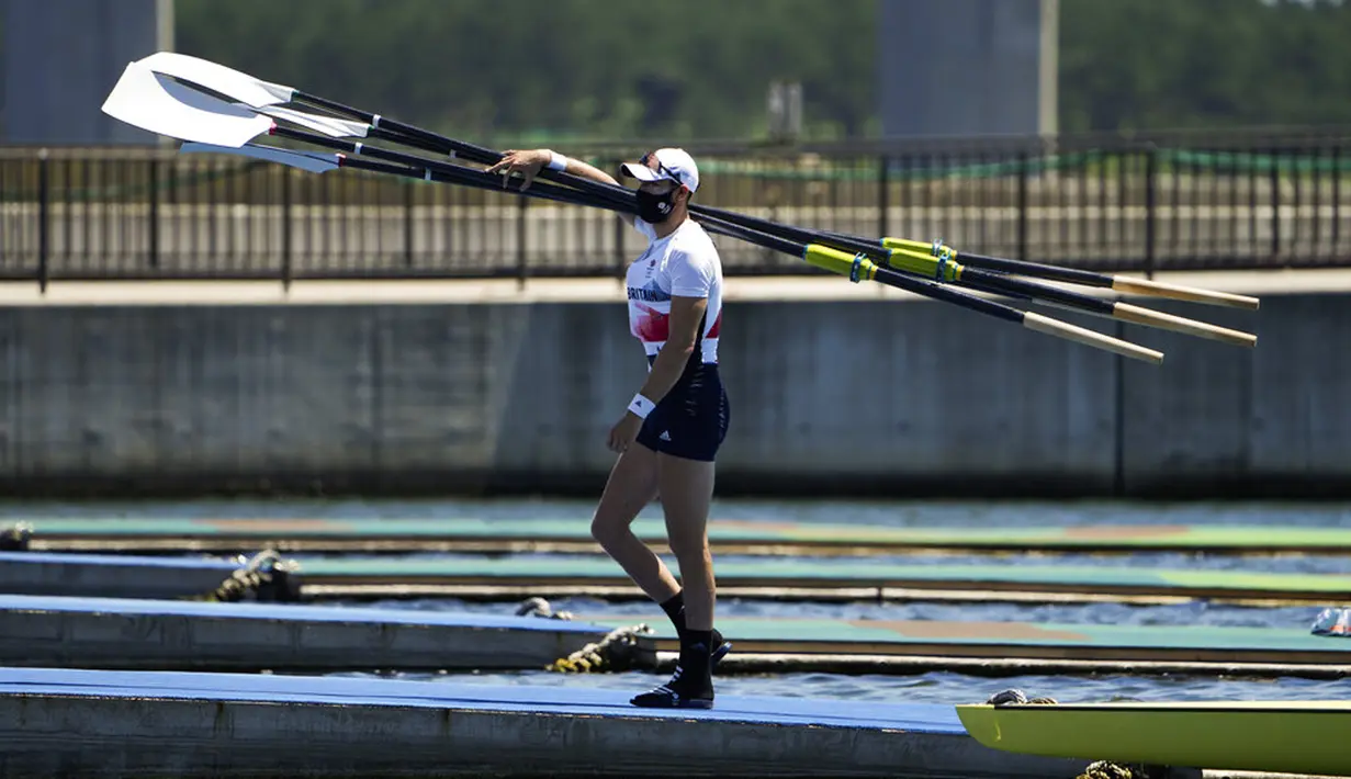 Seorang pendayung Inggris membawa dayung setelah sesi latihan jelang Olimpiade Tokyo 2020 di Sea Forest Waterway, Tokyo, Jepang, Minggu (18/7/2021). Olimpiade Tokyo 2020 dijadwalkan bergulir mulai 23 Juli hingga 8 Agustus 2021. (AP Photo/Jae C. Hong)