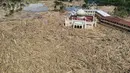 Di Kabupaten Aceh Tamiang, Provinsi Aceh, proses pemulihan berjalan lambat lantaran infrastruktur yang terputus, lumpur yang tak kunjung surut, dan tumpukan kayu sisa material banjir yang menutupi sebagian wilayah tersebut. Tampak dalam foto pemandangan udara menunjukkan sisa-sisa pepohonan yang tumbang di pesantren dan masjid Darul Mukhlisin setelah banjir bandang di Aceh Tamiang, pada Rabu 10 Desember 2025. (Aditya Aji/AFP)